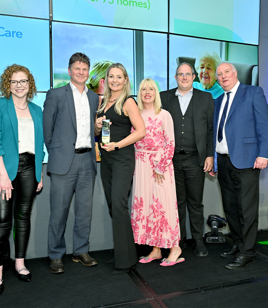 Group of professionals holding an award smiling